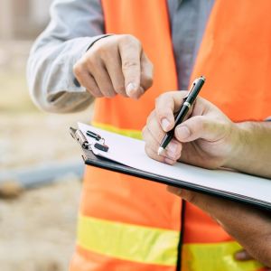 Physiotherapist writing on clipboard for client at job site